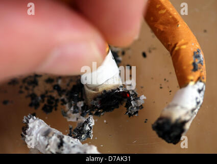 * Un homme une cigarette dans un cendrier à Cologne, Allemagne, 30 avril 2013. À compter du 01 mai, le resserrement des restrictions sur le tabagisme entrera en vigueur dans l'état allemand de Rhénanie du Nord-Westphalie. Il sera interdit de fumer dans les restaurants, bars, partie tentes, dans tous les équipements publics, sur des terrains de jeu, dans des stades de sport, dans tous les types d'installations culturelles et de loisirs et aussi dans les salles de jeu. Les nouvelles lois sur la protection des non-fumeurs permettra d'éliminer les échappatoires. Photo : Oliver Berg Banque D'Images