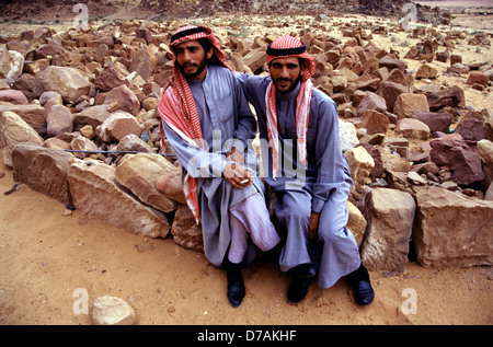 Lits jumeaux de Bédouins portant un keffieh à carreaux blancs et rouges et des robes traditionnelles dans le désert de Wadi Rum connu aussi sous le nom de la vallée de la lune, dans le sud de la Jordanie Banque D'Images