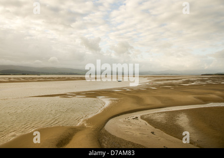 Une baie peu profonde durant la marée basse avec des formations de sable et des collines couvertes de bas nuages gris. Canal Duddon vasière. Banque D'Images