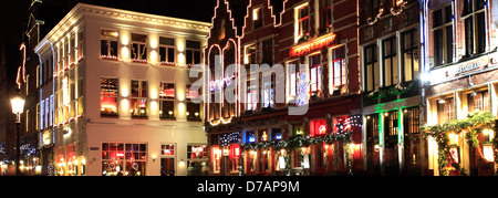 Décorations de Noël sur les bâtiments entourant la place du marché, la ville de Bruges, Flandre occidentale dans la région flamande de Belgique Banque D'Images