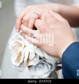 Un couple nouvellement marié tenir la main, l'affichage de leur mariage. Banque D'Images