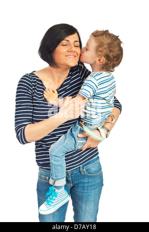 Tout-petit dans les bras de sa mère debout et l'embrassant joue isolé sur fond blanc Banque D'Images