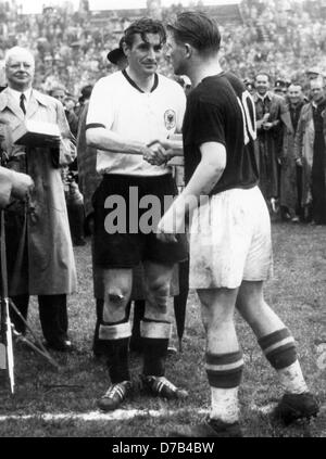 Le capitaine de l'équipe hongroise Ferenc Puskas (r) félicite le capitaine allemand Fritz Walter (l) sur la victoire allemande du championnat du monde le 4 juillet en 1954. L'Allemagne avait gagné contre la Hongrie avec 3:2. Dans l'arrière-plan à gauche le secrétaire général de la FIFA, Kurt Gassmann. Banque D'Images