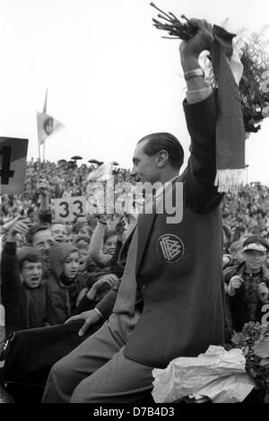 Accueil enthousiaste pour le joueur allemand Max internatinoal Morlock (avant) dans le stade de Nuremberg le 7 juillet en 1954 en face de 30 000 spectateurs. Morlock est forme de l'arrière voiture pour jeunes étudiants. L'équipe nationale de football allemande avec Morlock a remporté le FIFA 1954 sensationelle finale de la Coupe du Monde - 3:2 contre la Hongrie, pour la première fois remporter un titre de Coupe du monde. Populaires Morlock avait obtenu l'attaquant 1:2 réducteur. Banque D'Images