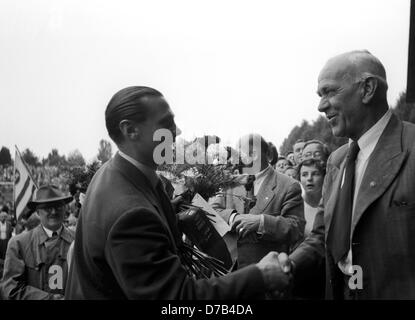 Accueil enthousiaste par 30 000 spectateurs pour national soccer player Max Morlock (l) le 7 juillet en 1954 à Nuremberg. Il est accueilli par Heiner Suhlfauth (r), un ancien gardien de but légendaire de Nuremberg. L'équipe nationale allemande avec Morlock venait de gagner la finale de championnat du monde contre la Hongrie avec 3:2. Morlock avait frappé les 1:2 objectif. Banque D'Images