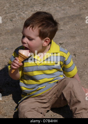 Jeune garçon qui mange une glace, UK 2013 Banque D'Images