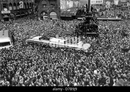 Accueil enthousiaste pour l'équipe nationale de football allemande à Munich le 6 juillet en 1954. Des milliers de personnes se sont pressées autour de l'autobus de tournée contenant les épouses et petites amies des joueurs. L'Allemagne a joué un match à la finale de la Coupe du Monde de la FIFA 1954 et a gagné 3:2 contre la Hongrie il y a deux jours, remportant le titre pour la première fois. Banque D'Images