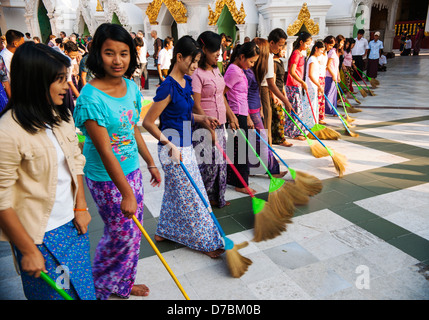 Les femmes bouddhistes balayant le sol, la pagode Shwedagon, Yangon, Birmanie (Myanmar) Banque D'Images