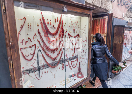 Une femme entre dans une boutique de colliers de corail dans le centre historique d'Alghero, Sardaigne Banque D'Images