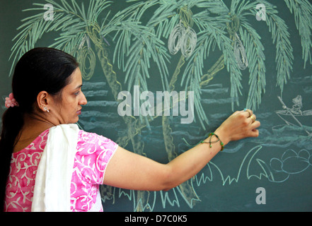 Indian female teacher dessin à la craie sur tableau noir Banque D'Images