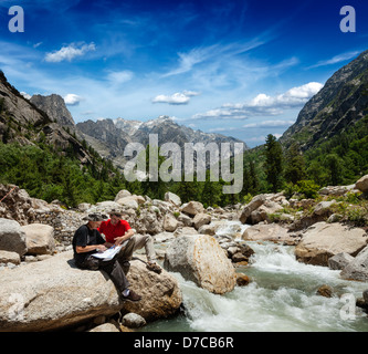 Les randonneurs randonneurs lire un trekking carte sur trek dans l'Himalaya, les montagnes. L'Himachal Pradesh, Inde Banque D'Images