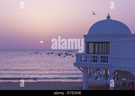 Coucher du soleil dans l'océan Atlantique. Ancienne station balnéaire sur la plage de Cadix. Andalusía​​, Espagne. Banque D'Images