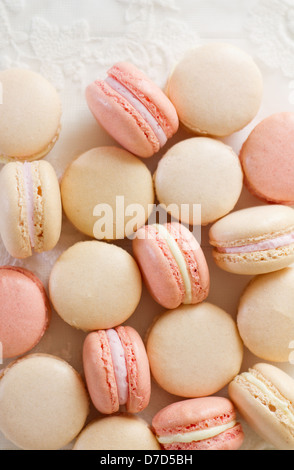 Une pile de macarons amande français sur bois blanc et dentelle, partie d'une série. Banque D'Images