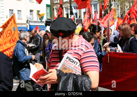 Défilé de jour de mai à Londres, 2013. Un participant indique que la documentation sur l'événement à un décrochage sur le vert. Banque D'Images