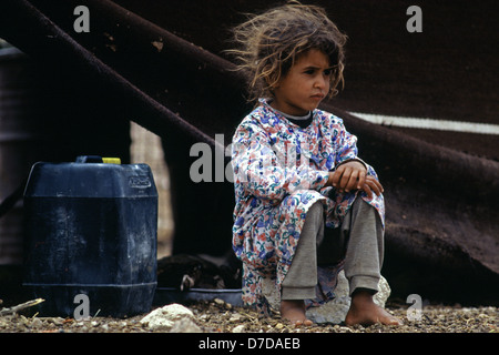 Un bédouin se trouve en dehors de sa fille tente familiale qui appartient à la tribu Zawaideh, originaire de les déserts du sud de la Jordanie et de l'ouest de l'Arabie saoudite assis à un campement de tentes dans le désert de Wadi Rum Jordanie Banque D'Images