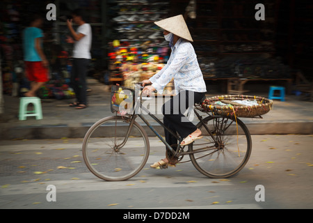 Un vendeur de rue sur son vélo dans le vieux quartier de Hanoi, Vietnam Banque D'Images