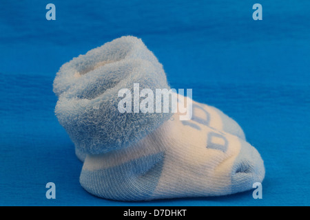 Cute Baby socks bleu et blanc sur fond bleu Banque D'Images