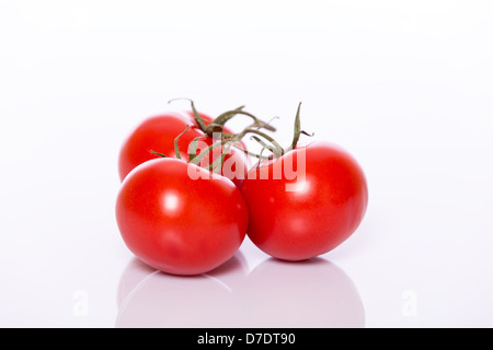 Trois tomates rondes rouges brillants dans grape Banque D'Images