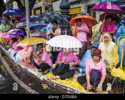 Bangkok, Thaïlande. 5 mai, 2013. Les thaïs attendre sous la pluie pour voir Bhumibol Adulyadej, le Roi de Thaïlande, dimanche. Le 5 mai marque le 63e anniversaire du couronnement de Sa Majesté le Roi Bhumibol Adulyadej. La journée est célébrée comme une fête nationale ; depuis cette année, il tombe un dimanche, le jour férié sera célébrée le lundi 6 mai, et à ce titre tous les bureaux gouvernementaux et les banques commerciales se ferme pour la journée. Sa Majesté le Roi Bhumibol Adulyadej est le plus ancien monarque régnant dans le monde. Chaque année, le 5 mai, le Royaume de Thaïlande commémore le jour où, en 1950, la cérémonie du Couronnement Banque D'Images