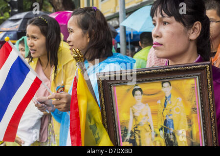 Bangkok, Thaïlande. 5 mai, 2013. Une femme thaïlandaise est titulaire d'une vieille photo de Bhumibol Adulyadej, le Roi de Thaïlande, et de son épouse la reine Sirikit dimanche. Le 5 mai marque le 63e anniversaire du couronnement de Sa Majesté le Roi Bhumibol Adulyadej. La journée est célébrée comme une fête nationale ; depuis cette année, il tombe un dimanche, elle sera célébrée le lundi 6 mai, et à ce titre tous les bureaux gouvernementaux et les banques commerciales se ferme pour la journée. Sa Majesté le Roi Bhumibol Adulyadej est le plus ancien monarque régnant dans le monde. Chaque année, le 5 mai, le Royaume de Thaïlande commémore le jour où, en 1950, Banque D'Images