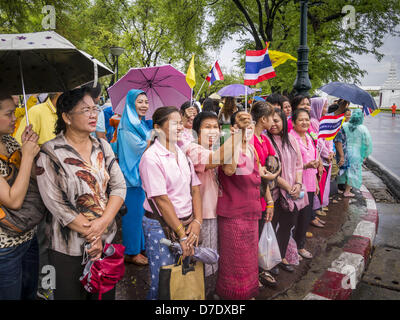 Bangkok, Thaïlande. 5 mai, 2013. Les thaïs attendre sous la pluie pour voir Bhumibol Adulyadej, le Roi de Thaïlande, dimanche. Le 5 mai marque le 63e anniversaire du couronnement de Sa Majesté le Roi Bhumibol Adulyadej. La journée est célébrée comme une fête nationale ; depuis cette année, il tombe un dimanche, le jour férié sera célébrée le lundi 6 mai, et à ce titre tous les bureaux gouvernementaux et les banques commerciales se ferme pour la journée. Sa Majesté le Roi Bhumibol Adulyadej est le plus ancien monarque régnant dans le monde. Chaque année, le 5 mai, le Royaume de Thaïlande commémore le jour où, en 1950, la cérémonie du Couronnement Banque D'Images