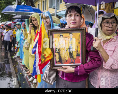 Bangkok, Thaïlande. 5 mai, 2013. Une femme thaïlandaise est titulaire d'une vieille photo de Bhumibol Adulyadej, le Roi de Thaïlande, et de son épouse la reine Sirikit dimanche. Le 5 mai marque le 63e anniversaire du couronnement de Sa Majesté le Roi Bhumibol Adulyadej. La journée est célébrée comme une fête nationale ; depuis cette année, il tombe un dimanche, elle sera célébrée le lundi 6 mai, et à ce titre tous les bureaux gouvernementaux et les banques commerciales se ferme pour la journée. Sa Majesté le Roi Bhumibol Adulyadej est le plus ancien monarque régnant dans le monde. Chaque année, le 5 mai, le Royaume de Thaïlande commémore le jour où, en 1950, Banque D'Images