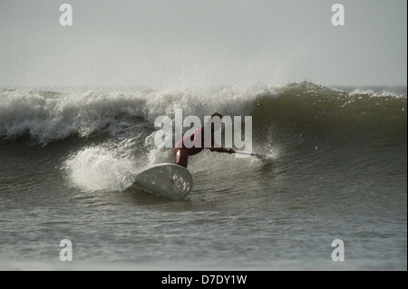 Stand Up Paddle board surfer Chris Griffiths, Champion britannique montre la voie classique de l'autre côté de la vague des surfeurs. Séquence. Banque D'Images