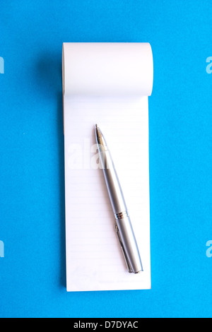 A ouvert des pages vierges avec stylo portable isolé sur fond bleu Banque D'Images