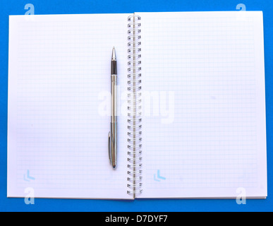 Ordinateur portable ouvert avec des pages blanches avec stylo isolé sur fond bleu Banque D'Images