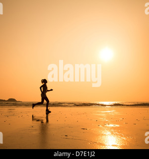 Exécuter pour fin, silhouette de femme sur la plage Banque D'Images