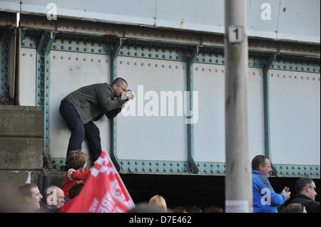 CARDIFF, Royaume-Uni. 5 mai 2013. Un fan monte sur un pont pour photographier le défilé des champions de la ville de Cardiff.L'équipe n'ont défilé dans la ville dans un bus à toit ouvert après avoir remporté le championnat et d'être promu en Premier League. Banque D'Images