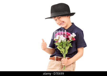 Un mignon petit garçon avec un chapeau holding bunch of flowers, isolé sur fond blanc Banque D'Images