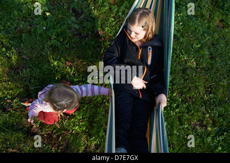 Deux enfants blondes se reposant dans un hamac l'heure d'été Banque D'Images