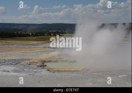 Ciel bleu nuages blancs voir l'éruption de vapeur d'eau chaude vertical de clepsydre, Geyser Geyser Basin, Yellowstone, États-Unis Banque D'Images