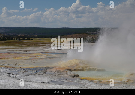 Ciel bleu nuages blancs voir l'éruption de vapeur d'eau chaude cône coloré clepsydre, Geyser Geyser Basin, Yellowstone, États-Unis Banque D'Images