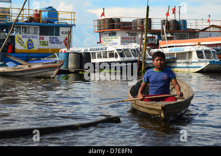 Les palettes d'un garçon à travers le fleuve Amazone port de Bellavista Nanay, à Iquitos, Pérou. Banque D'Images