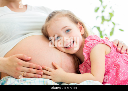 Happy kid girl hugging pregnant mother's belly Banque D'Images