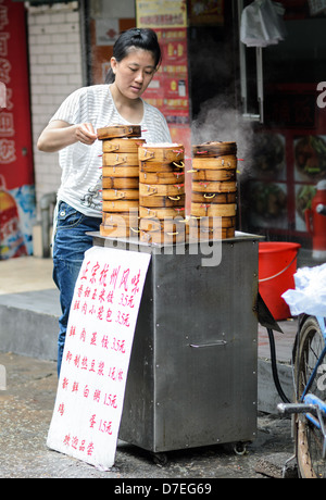 Femme chinoise s'empilent les dim sum au petit matin. Comme les scènes de ce sont caractéristiques du sud de la Chine Banque D'Images