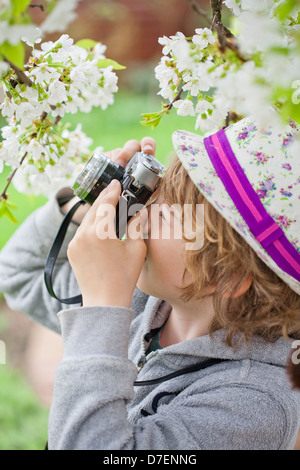 Garçon photographié dans le jardin. Banque D'Images