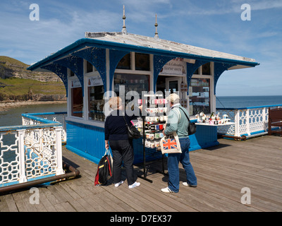 Couple de personnes âgées à la recherche de souvenirs sur la jetée de Llandudno Galles UK Banque D'Images