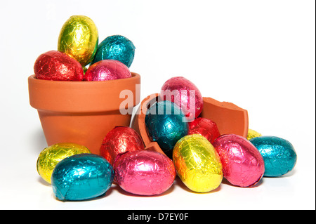 Les oeufs de Pâques en chocolat de couleur terre cuite et pot de fleurs, isolé sur fond blanc Banque D'Images