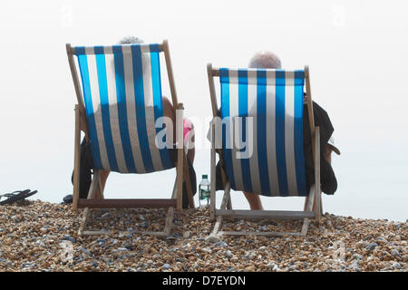 Brighton, UK. 6 mai, 2013. Un couple assis sur des transats sur la plage de Brighton en grandes foules d'amateurs de plage affluent à la mer pour profiter du soleil sur les vacances de banque que les températures en Grande-Bretagne ont grimpé en flèche. Credit : Amer Ghazzal/Alamy Live News Banque D'Images