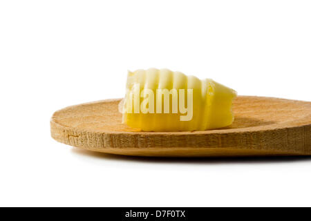 Curl beurre sur une cuillère en bois sur fond blanc Banque D'Images