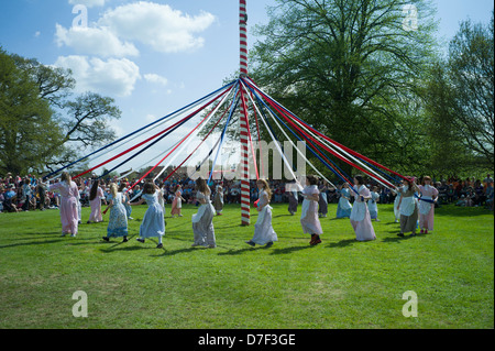 Peut Pole Dancing, Ickwell, Bedfordshire, Angleterre,mai 2013. Les enfants danser autour du mât sur la place du village à Ickwell. Banque D'Images