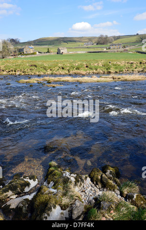 À la recherche de l'autre côté de la rivière Wharfe près de Tonbridge vers les bâtiments de ferme sur le sentier du Yorkshire Dales Way Wharfedale. Banque D'Images