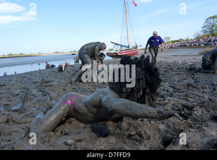 Un coureur est coincé dans la boue et demande une main dans finir la course. La boue Maldon Race est un événement annuel. Banque D'Images