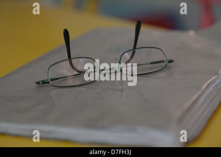 Gros plan sur une paire de lunettes sur le dessus d'un livre scolaire Banque D'Images