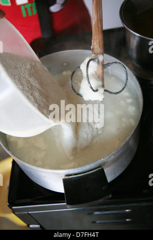 Libre d'une femme africaine la préparation de bouillie sur une cuisinière électrique Banque D'Images