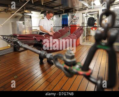 Un membre d'équipage est à côté d'hamacs sous le pont de l'école navire 'Gorch Fock' à Hambourg, Allemagne, 07 mai 2013. La marine allemande a 89 mètre de long Tall Ship est amarré à Hambourg au plomb dans le traditionnel défilé pour l'anniversaire du port le 09 mai 2013. Photo : ANGELIKA WARMUTH Banque D'Images