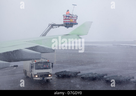 Traitement des fluides de dégivrage des avions ailes pendant une forte tempête de neige. Banque D'Images